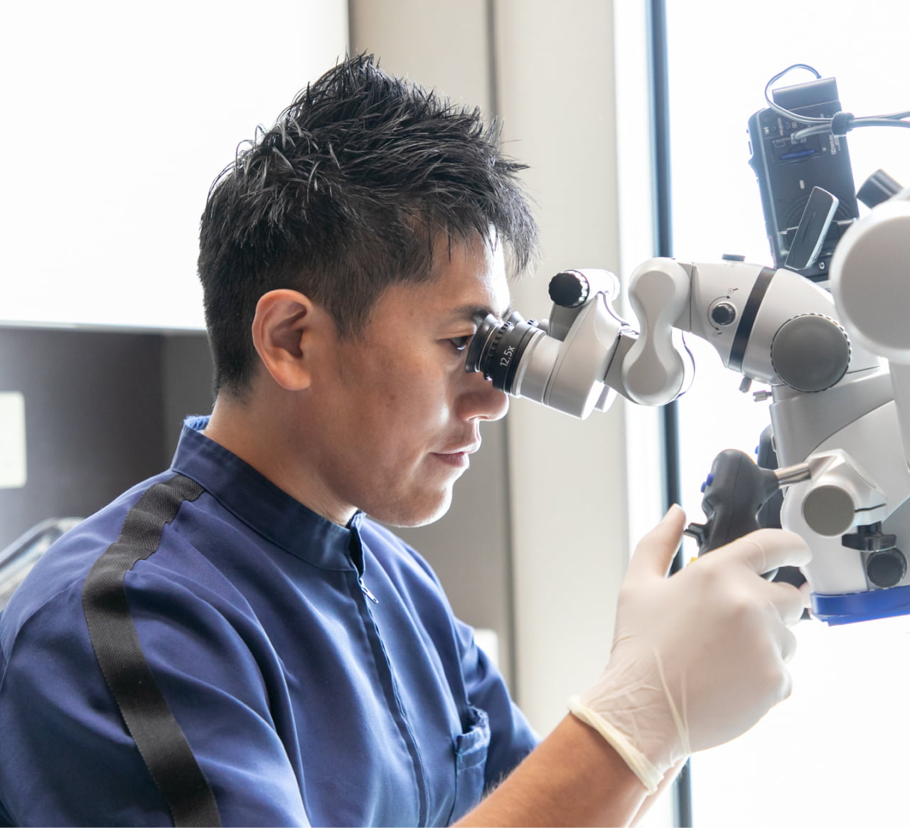 マイクロスコープを見る院長